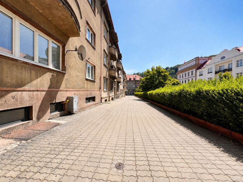 Na prenájom 1 izbový byt po rekonštrukcii – Banská Bystrica/centrum - Mestská ulica s bytovými domami a upraveným chodníkom.
