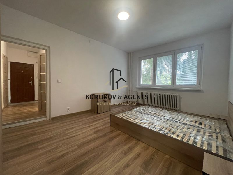 PRENÁJOM, 2 izb. byt na Považskej ulici, Košice - Západ - Spálňa v 2-izbovom byte s podlahou s dreveným dekorom a veľkými oknami.