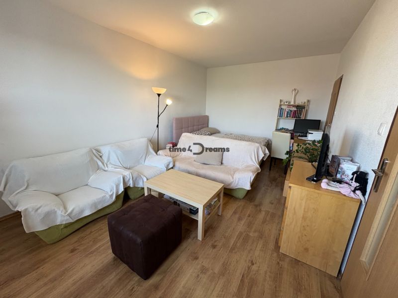 Na predaj: Veľký 2 izb.byt + LOGGIA + ŠPAJZA + PIVNICA - Obývacia izba 2-izbového bytu s podlahou s dreveným dekorom, pohovkou a posteľou.