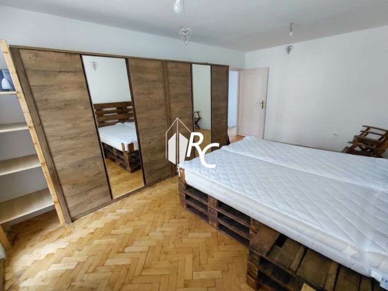 2 izbový byt v CENTRE Martina s veľkou loggiou - Spálňa v 2-izbovom byte s podlahou s dreveným dekorom a veľkou skriňou.