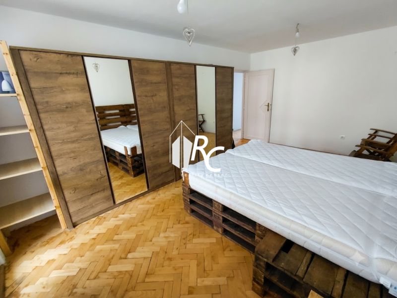 2 izbový byt v CENTRE Martina s veľkou loggiou - Spálňa v 2-izbovom byte s podlahou s dreveným dekorom a priestrannou skriňou.