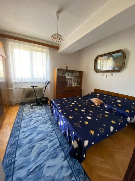 Predaj 3 izbového bytu vo Vyhniach - Spálňa v 3-izbovom byte s posteľou, behúňom, obrazom a cvičebným strojom.