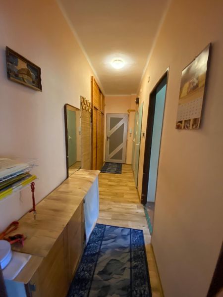 Predaj 3 izbového bytu vo Vyhniach - Chodba so vstupnými dverami v 3-izbovom byte, drevená skriňa a koberec.