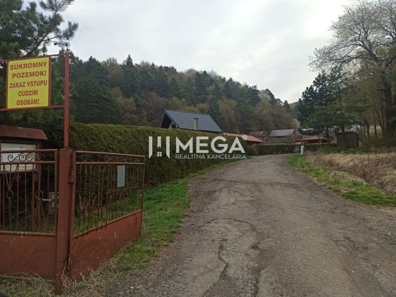 Na predaj pozemok/záhradka v záhradkárskej osade Poniklec Humenné - Cesta vedúca do záhrad v Humennom lemovaná stromami a plotmi s tabuľou zákazu vstupu.