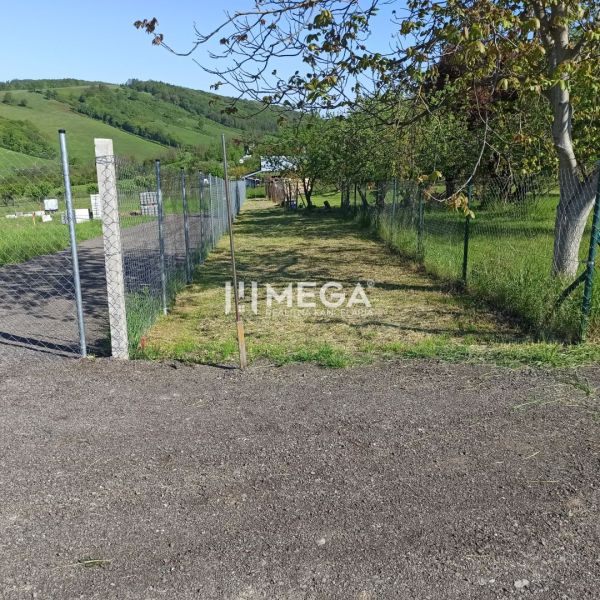 Na predaj stavebný pozemok priamo v meste Humenné - Pozemok na bývanie v Humennom na oplotenej ulici, obklopený zeleňou.