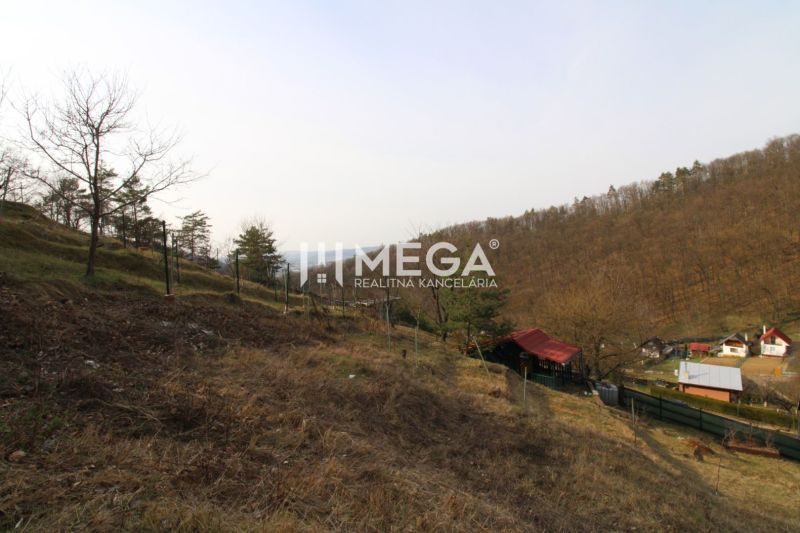 NA PREDAJ pozemok 800m2 v ZO Poniklec pri meste Humenné - Záhrady v lokalite ZO Poniklec, Humenné, s trávnatou plochou na svahu a domčekmi v údolí.