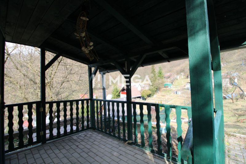 NA PREDAJ pozemok 800m2 v ZO Poniklec pri meste Humenné - Zastrešená terasa so zeleným zábradlím v Záhradách na ZO Poniklec, Humenné.
