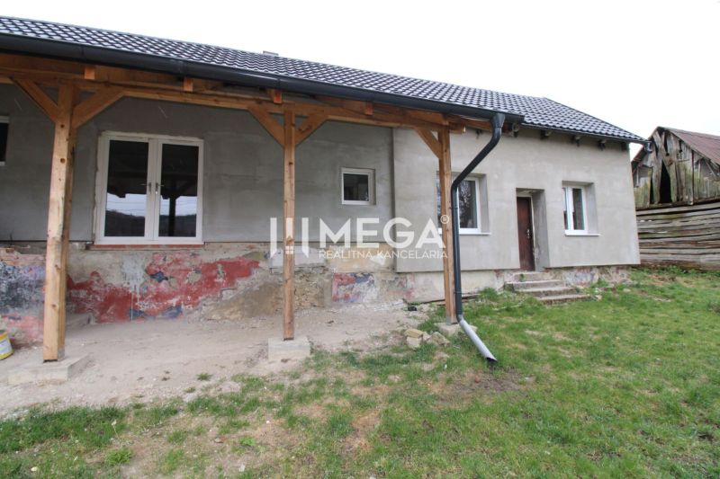 Na predaj - Dom s veľkým pozemkom v Pakostove - Rodinný dom v Pakostove s nezateplenou fasádou a trámovou verandou na ulici Pakostov.