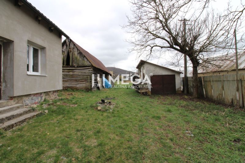 Na predaj - Dom s veľkým pozemkom v Pakostove - Záhrada pri rodinnom dome na ulici v Pakostove, so staršou drevenou kôlňou a trávnikom.