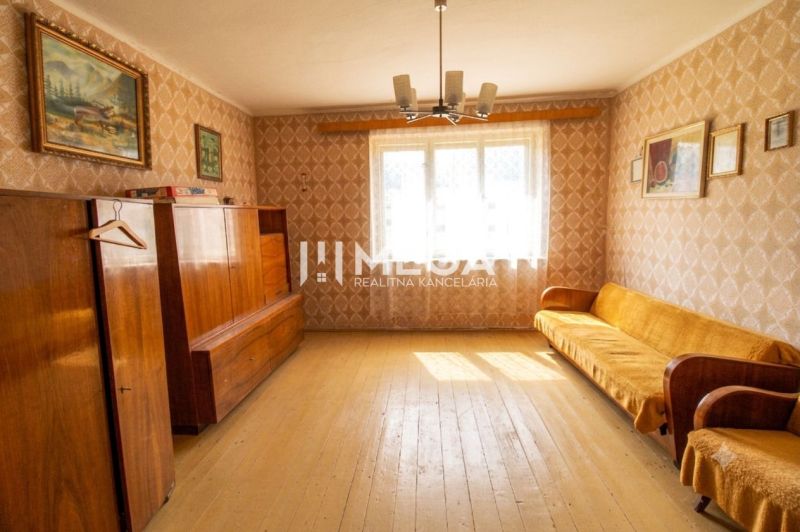 REZERVOVANÉ - Dom s krásnym pozemkom v Zbudskej Belej - Obývačka rodinného domu s retro nábytkom a podlahou s dreveným dekorom.