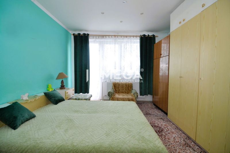 PREDAJ RODINNÉHO DOMU v obci LACKOVCE (HE) - Spálňa v rodinnom dome s tyrkysovou stenou, veľkou posteľou a skriňami.