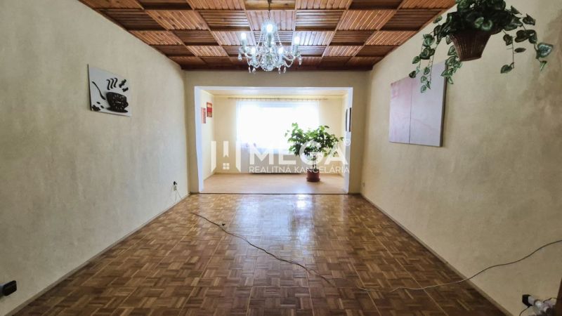 PREDAJ RODINNÉHO DOMU v obci LACKOVCE (HE) - Obývacia izba v rodinnom dome s podlahou s dreveným dekorom a lustrom.