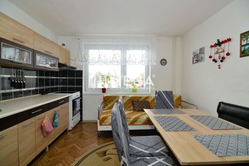 PREDAJ RODINNÉHO DOMU v obci LACKOVCE (HE) - Kuchyňa v rodinnom dome s kuchynskou linkou a jedálenským stolom, podlaha s dreveným dekorom.
