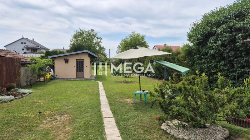 PREDAJ RODINNÉHO DOMU v obci LACKOVCE (HE) - Záhrada rodinného domu v Lackovciach s trávnikom, posedením a drobnou stavbou.