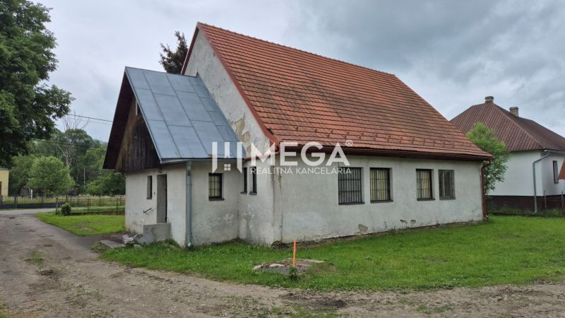 Predaj budovy v obci Zboj - Budova s červenou strechou v Zboji obklopená zeleňou a susednými domami, využiteľná ako obchodné priestory.