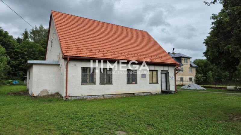 Predaj budovy v obci Zboj - Budova v Zboji s červenou strechou a trávnatým okolím. Obchodné priestory dostupné.