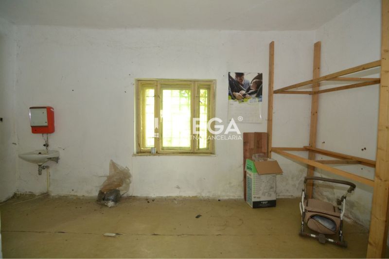 Prenájom časti komerčnej budovy na podnikanie – Stakčín - Obchodné priestory s jednoduchým umývadlom, policami a oknom, bez podlahy s dreveným dekorom.