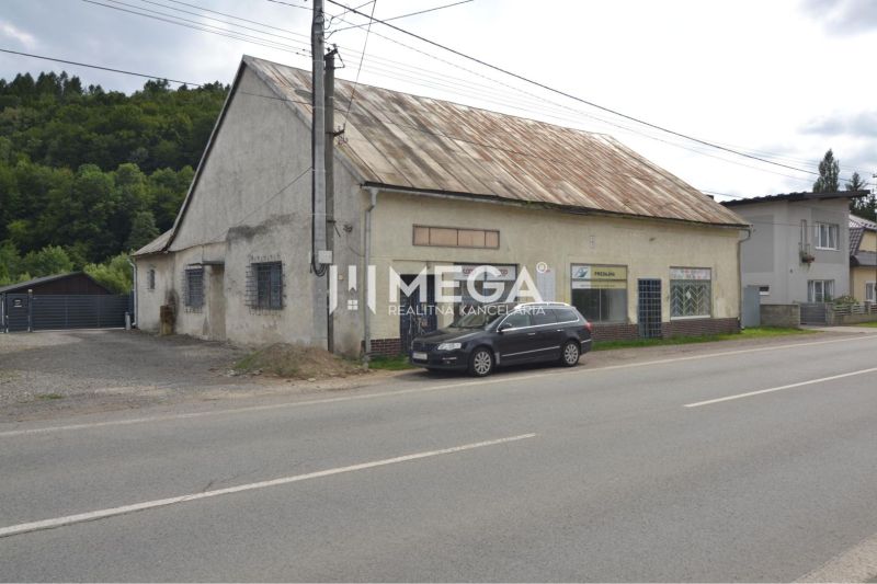 Prenájom časti komerčnej budovy na podnikanie – Stakčín - Budova na ulici Mieru v Stakčíne, využívaná ako obchodné priestory, vedľa zaparkované auto.