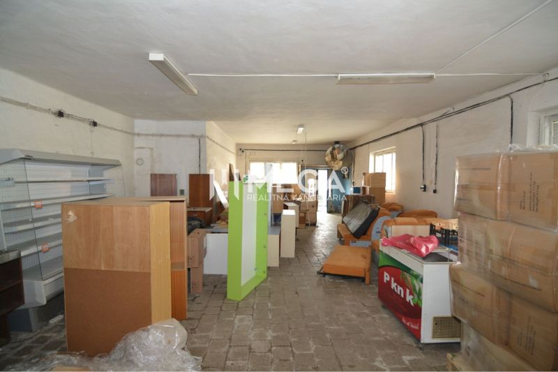 Prenájom časti komerčnej budovy na podnikanie – Stakčín - Obchodné priestory s uloženými regálmi, boxmi a zariadením, podlaha s dreveným dekorom.