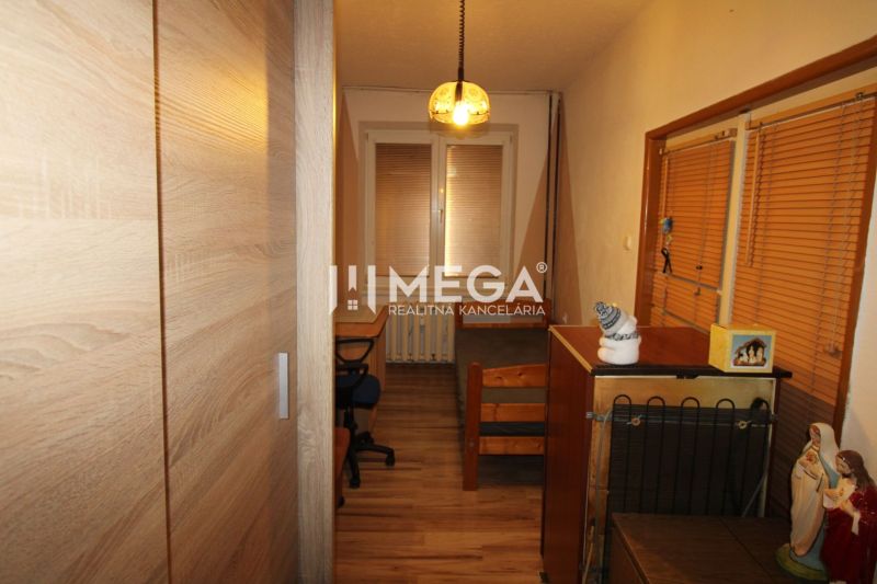 Na predaj: Ideálny byt na rekonštrukciu – 4 izby, Snina - Detská izba v 3-izbovom byte s pracovným stolom, skriňou a podlahou s dreveným dekorom.