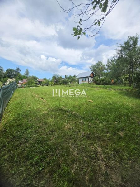 Záhrada na predaj – 365 m², Pichoňka, Snina - Pohľad na zelené záhrady v Snine s viditeľnými chatkami a modrou oblohou.