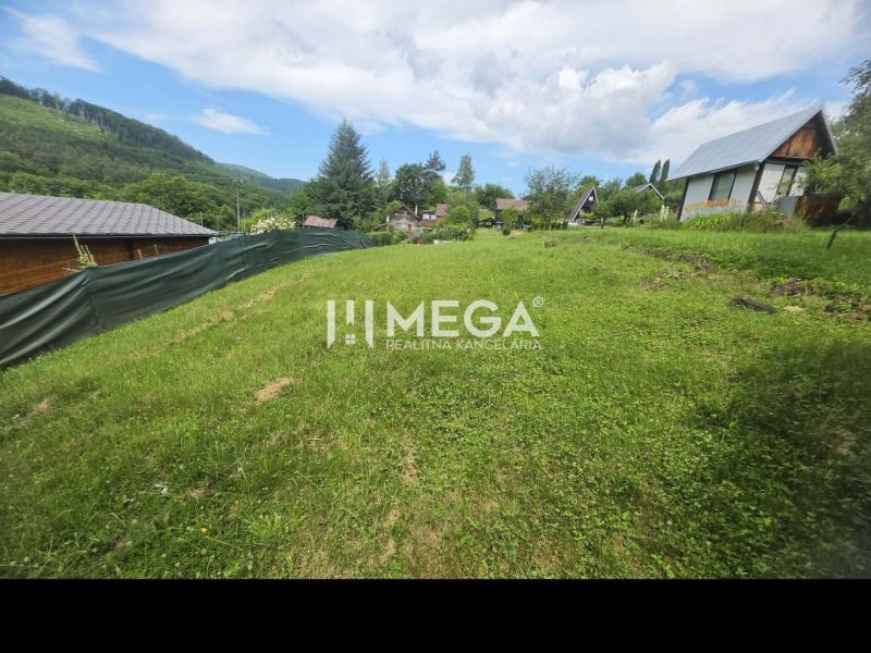 Záhrada na predaj – 365 m², Pichoňka, Snina - Záhrady v Snine na Snine s trávnikom, oplotením a výhľadom na hory v pozadí.