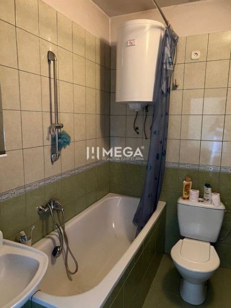 Ponúkame na predaj rodinný dom v Zboji - Kúpeľňa s vaňou a toaletou obložená zelenými obkladačkami v rodinnom dome.