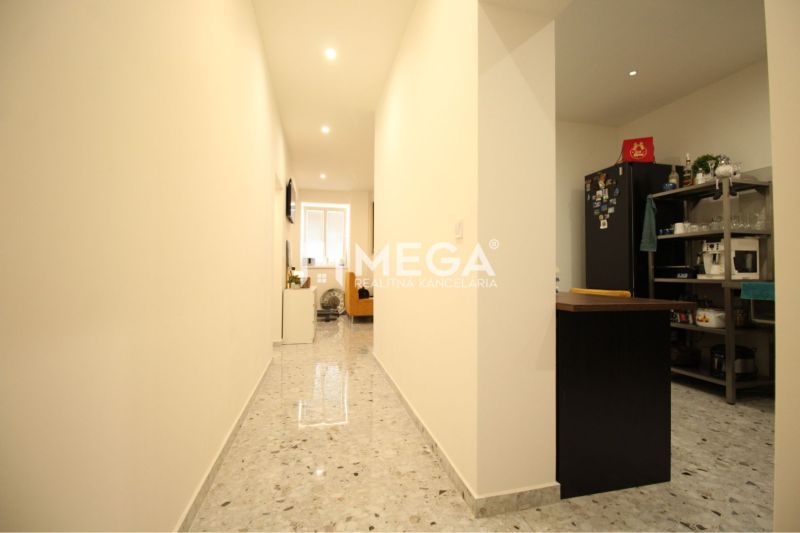 NA PRENÁJOM: Kancelárske priestory + 3-izbový apartmán – Košice - Interiér budovy s dláždenou chodbou, kuchyňou a spotrebičmi po stranách.