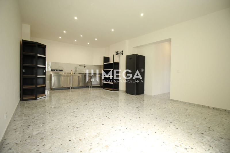 NA PRENÁJOM: Kancelárske priestory + 3-izbový apartmán – Košice - Interiér budovy s kuchynskou linkou, čiernymi policami a lesklou podlahou.