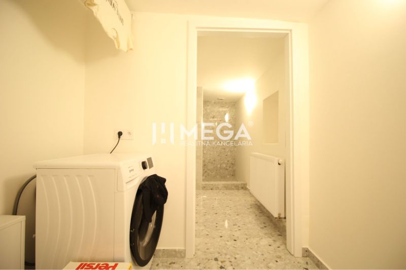 NA PRENÁJOM: Kancelárske priestory + 3-izbový apartmán – Košice - Práčovňa v budove s práčkou a sivou podlahou s dlažbou.