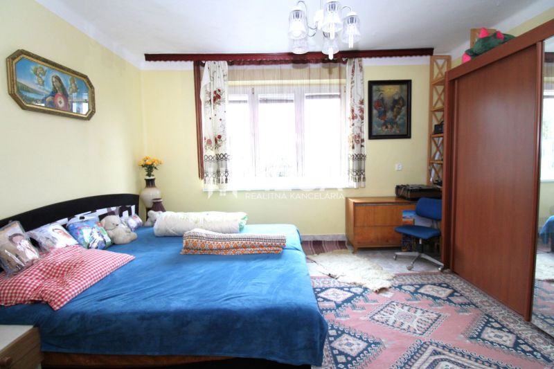 NA PREDAJ RODINNÝ DOM – MYSLINA ( len 6 km od Humenného) - Spálňa v rodinnom dome s modrou posteľou, dreveným nábytkom a farebným kobercom.
