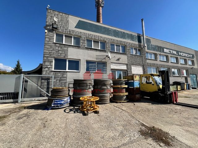 Ex. Prenájom hál/ skl. priestorov/výrobného priestoru vo Vrbovom   - Priestor skladu na Sídlisku 9. mája vo Vrbovom, obklopený rôznymi materiálmi.