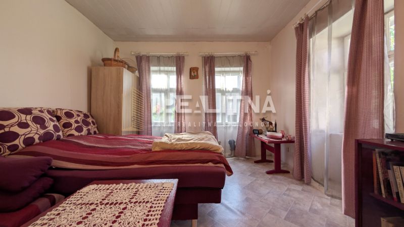 TRADIČNÝ DOM V SRDCI TAJOVA, 893 M2, TAJOV - Spálňa v rodinnom dome s posteľou, komodou a veľkými oknami s fialovými závesmi.