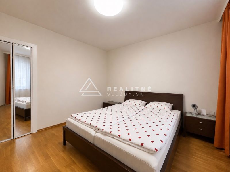 2-IZBOVÝ BYT S BALKÓNOM, ZIMNÁ ULICA, KOŠICE – STARÉ MESTO - Svetlá spálňa s posteľou a šatníkom v 2-izbovom byte, podlaha s dreveným dekorom.