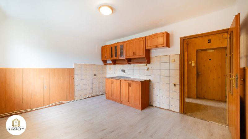 PREDAJ | 2-izb. byt 59 m² + loggia | Š. Michaľany - Kuchyňa v 2-izbovom byte s drevenými skrinkami a podlahou s dreveným dekorom.