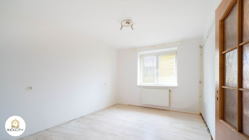 PREDAJ | 2-izb. byt 59 m² + loggia | Š. Michaľany - Prázdna izba s bielymi stenami a podlahou s dreveným dekorom v 2-izbovom byte.