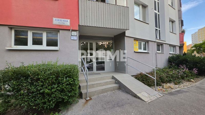 Priestranný a atypický 4i byt s dvoma loggiami, Furdekova, Petržalka - Vchod do bytového domu na Furdekovej ulici v Bratislave-Petržalke, obklopený zeleňou.
