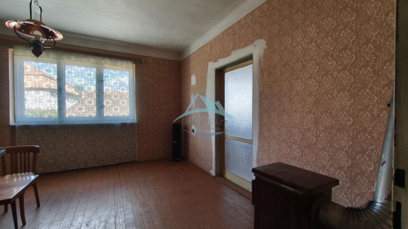 Znížená cena!!! Vidiecky dom v obci Olováry v okrese Veľký Krtíš. - Interiér rodinného domu s hnedou tapetou a podlahou s dreveným dekorom.