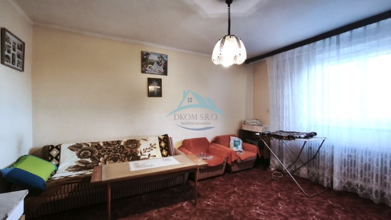 Znížená cena!!! RD (pozemok 9756 m2)  v osade Prieloh, okr. V. Krtíš. - Obývačka v rodinnom dome s pohovkami, stolom a záclonami na okne.
