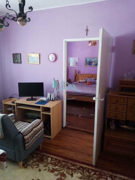 Váš nový rodinný prístav v obci Iža: Priestor, kľud a čerstvá úroda z  - Obývacia izba v rodinnom dome s fialovými stenami a podlahou s dreveným dekorom.