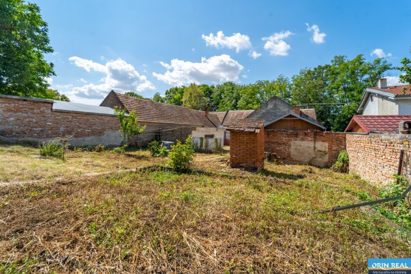 NA PREDAJ RODINNÝ DOM S POZEMKOM O VÝMERE 1003m2 - Záhrada pri rodinnom dome vo Vištuku na ulici Vištuk 158, obkolesená tehlovým múrom.