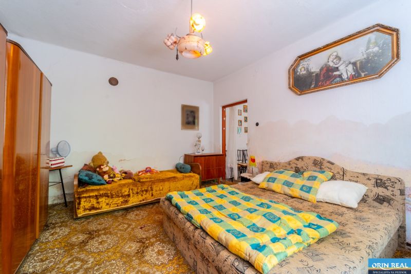 NA PREDAJ RODINNÝ DOM S POZEMKOM O VÝMERE 1003m2 - Spálňa v Rodinnom dome s posteľami, skriňou, kobercovou podlahou a dekoráciami.