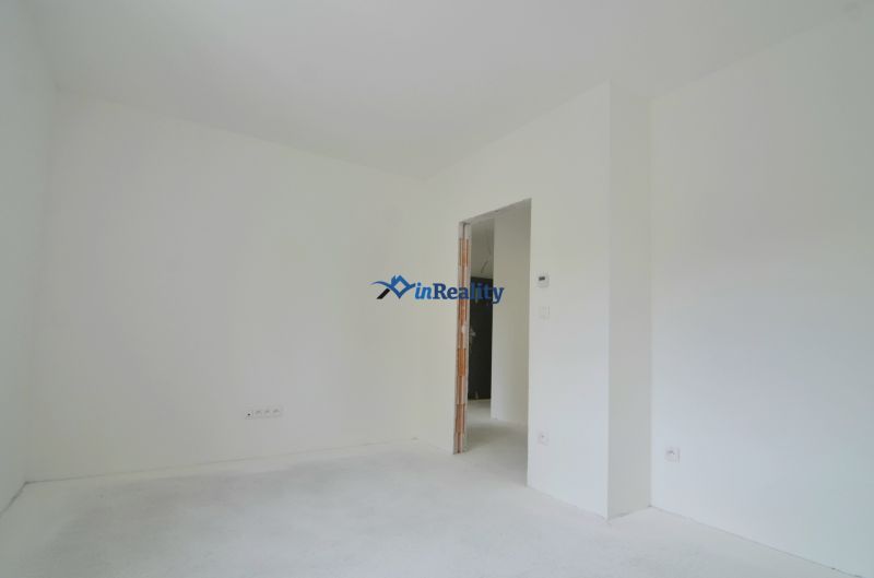3-izbový byt s balkónom v Rezidencii Madone - Svetlá izba s bielymi stenami a podlahou v 3-izbovom byte.