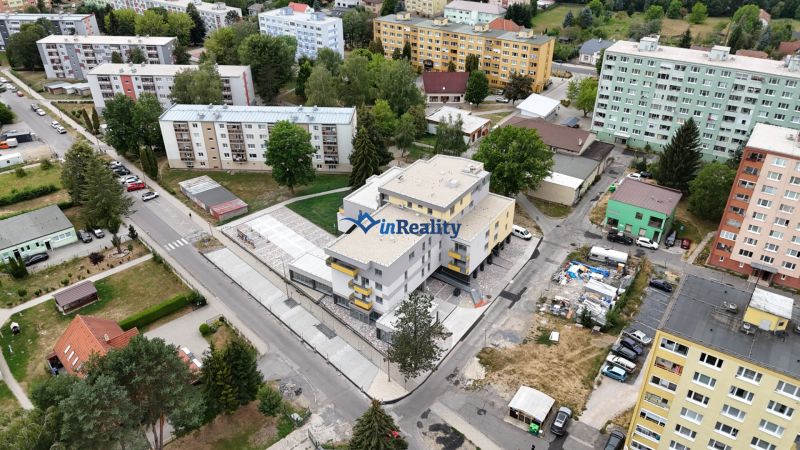3-izbový byt s balkónom v Rezidencii Madone - Pohľad na obytnú ulicu Školská v Hriňovej s 3-izbovými bytmi a zelenými plochami.