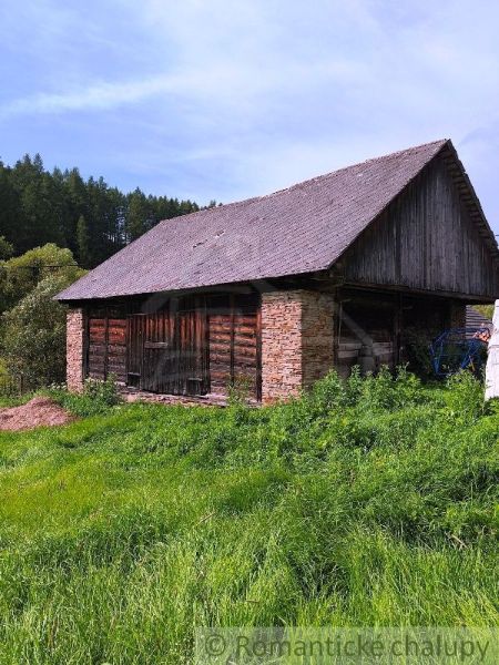 Pozemok s hospodárskymi budovami, Nižné Repaše - Drevená stodola obklopená zeleňou na pozemku v Nižných Repašoch.