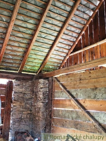 Pozemok s hospodárskymi budovami, Nižné Repaše - Drevený interiér s kamennou stenou v dome na Pozemky - bývanie.