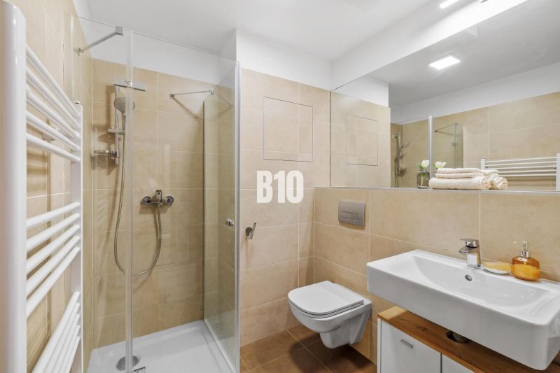 1-IZBOVÝ BYT S VEĽKOU 12 m² TERASOU | SLNEČNICE VILADOMY - Kúpeľňa s toaletou, sprchovým kútom a umývadlom v 1-izbovom byte.