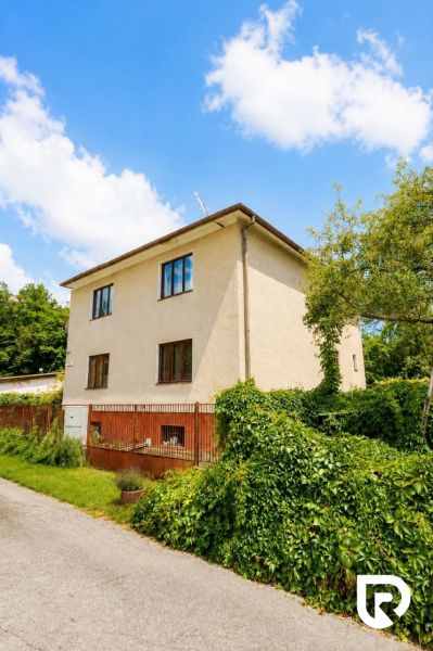 3-IZBOVÝ BYT 90 m² V RODINNOM DOME | POVAŽSKÝ CHLMEC - Žilina - Rodinný dom na ulici Pod Laščeky v Žiline, obklopený zelenou vegetáciou.