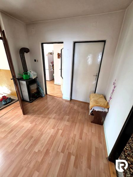 3-IZBOVÝ BYT 90 m² V RODINNOM DOME | POVAŽSKÝ CHLMEC - Žilina - Interiér rodinného domu s podlahou s dreveným dekorom, krbom a dveřami do iných miestností.