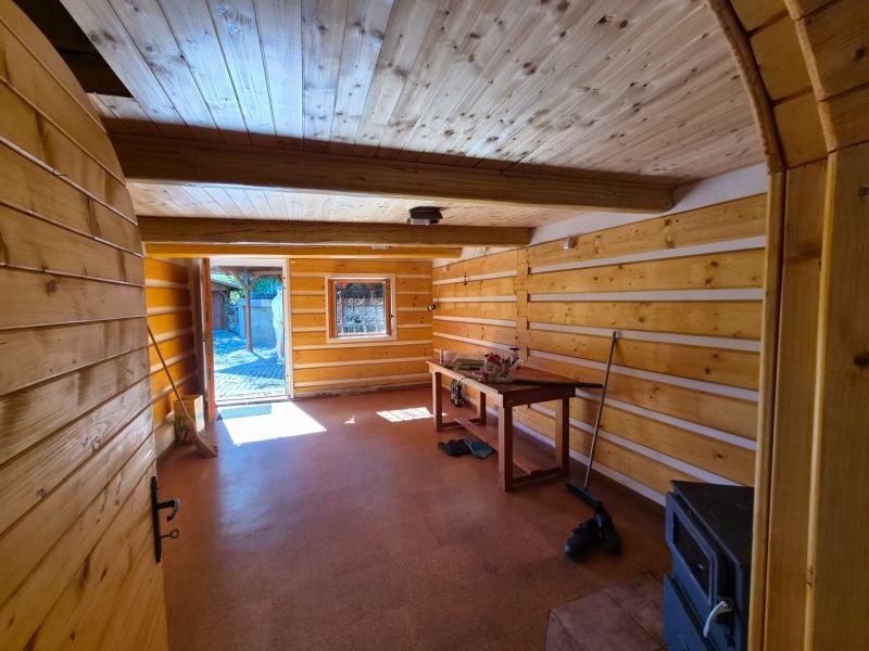 Víkendová chalupa Mikušovce, pozemok 281m2 - Drevený interiér rodinného domu s podlahou s dreveným dekorom a malým oknom.